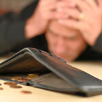 Empty,Wallet,On,The,Table,,Only,A,Few,Coins,Inside.