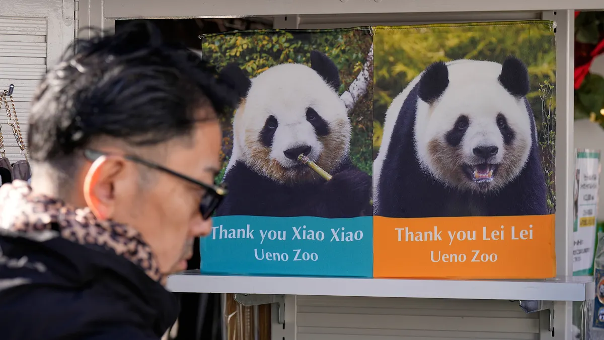 2025年12月16日，日本東京上野動物園內張貼著大熊貓「曉曉」與「蕾蕾」的照片海報。（美聯社）